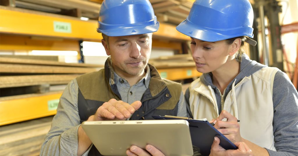 profissionais conferem através de sistema em um tablet o controle de estoque de materiais